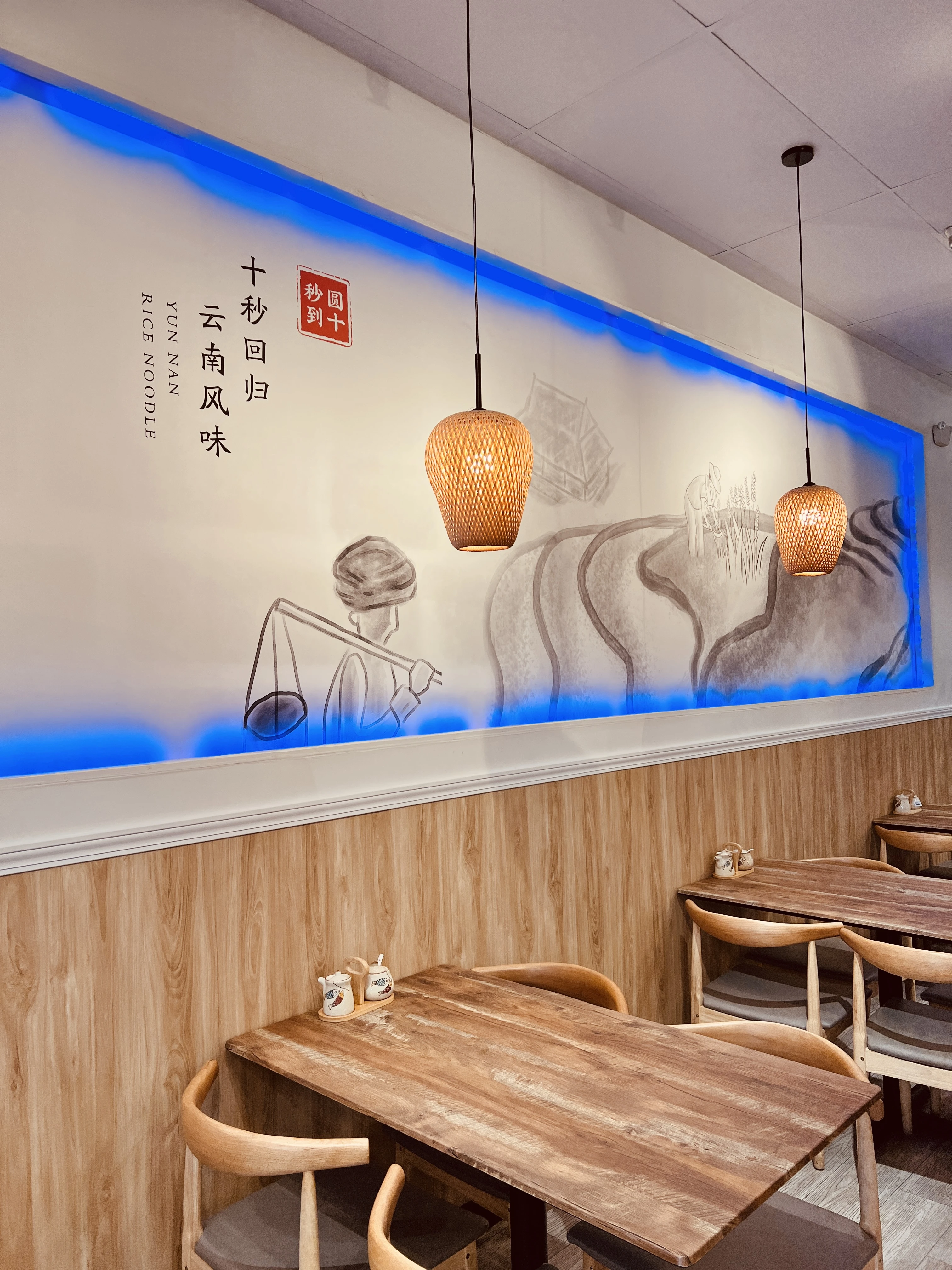 Blue-accent wall mural with pendant lighting in the dining room